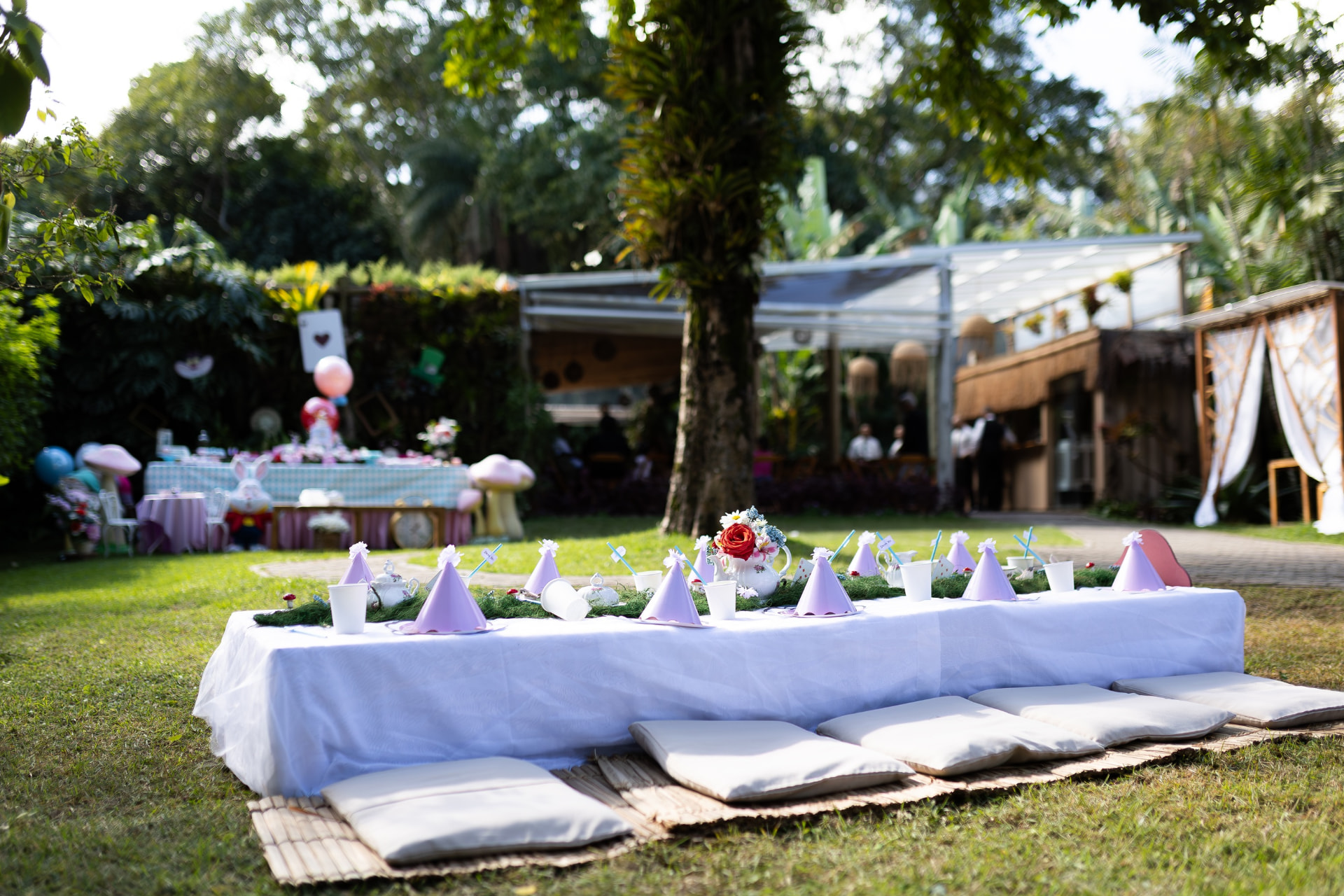 Mesa infantil montada na grama com chapéus de festa