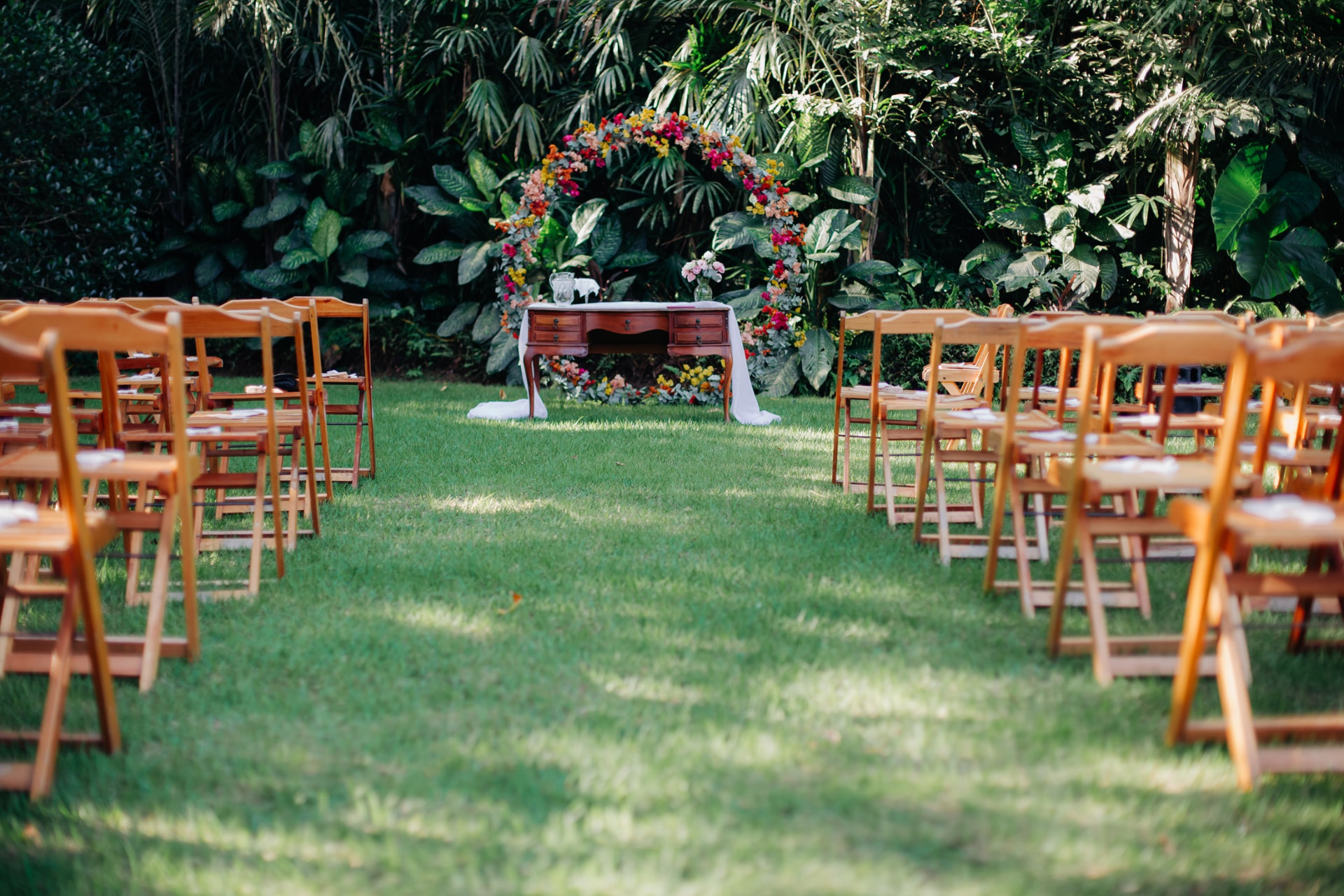 Altar de casamento com arco de flores no gramado do Jamboo