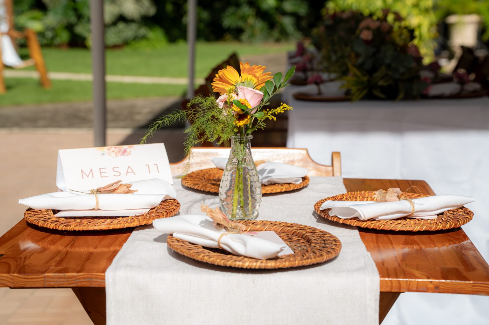 Mesa posta com sousplat de palha e flores